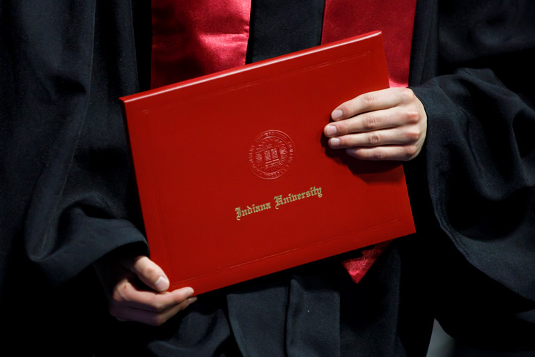 Hands cradling an IU diploma